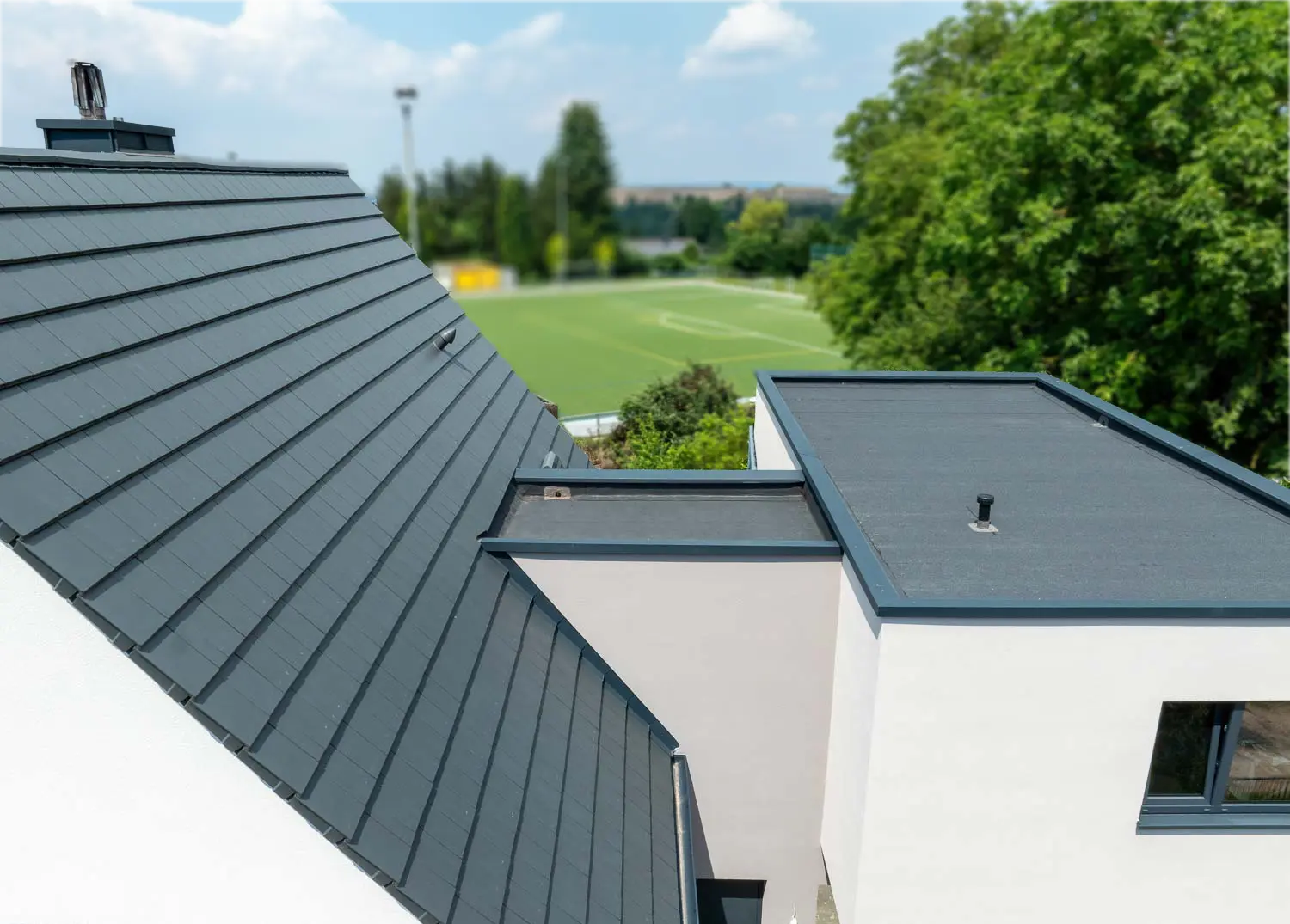 Modernes Wohnhaus mit Steildach und Flachdachabdichtung aus hochwertigem Dachsystem