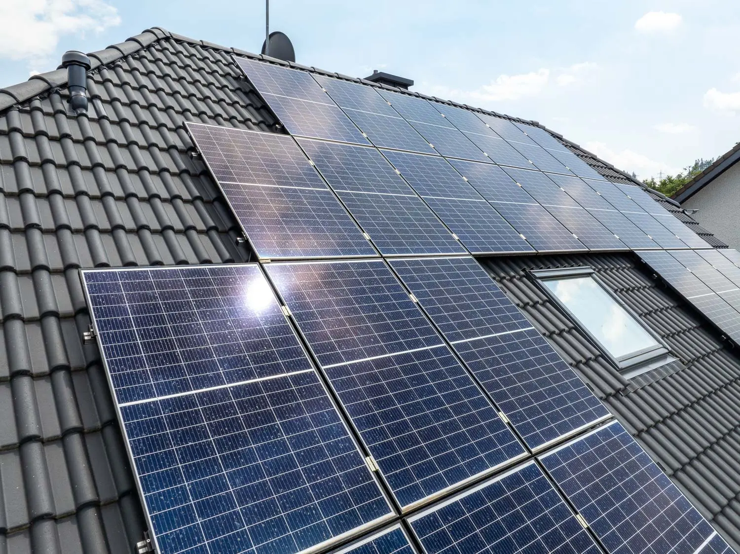 Photovoltaikanlage auf Ziegeldach eines Einfamilienhauses mit Dachfenster
